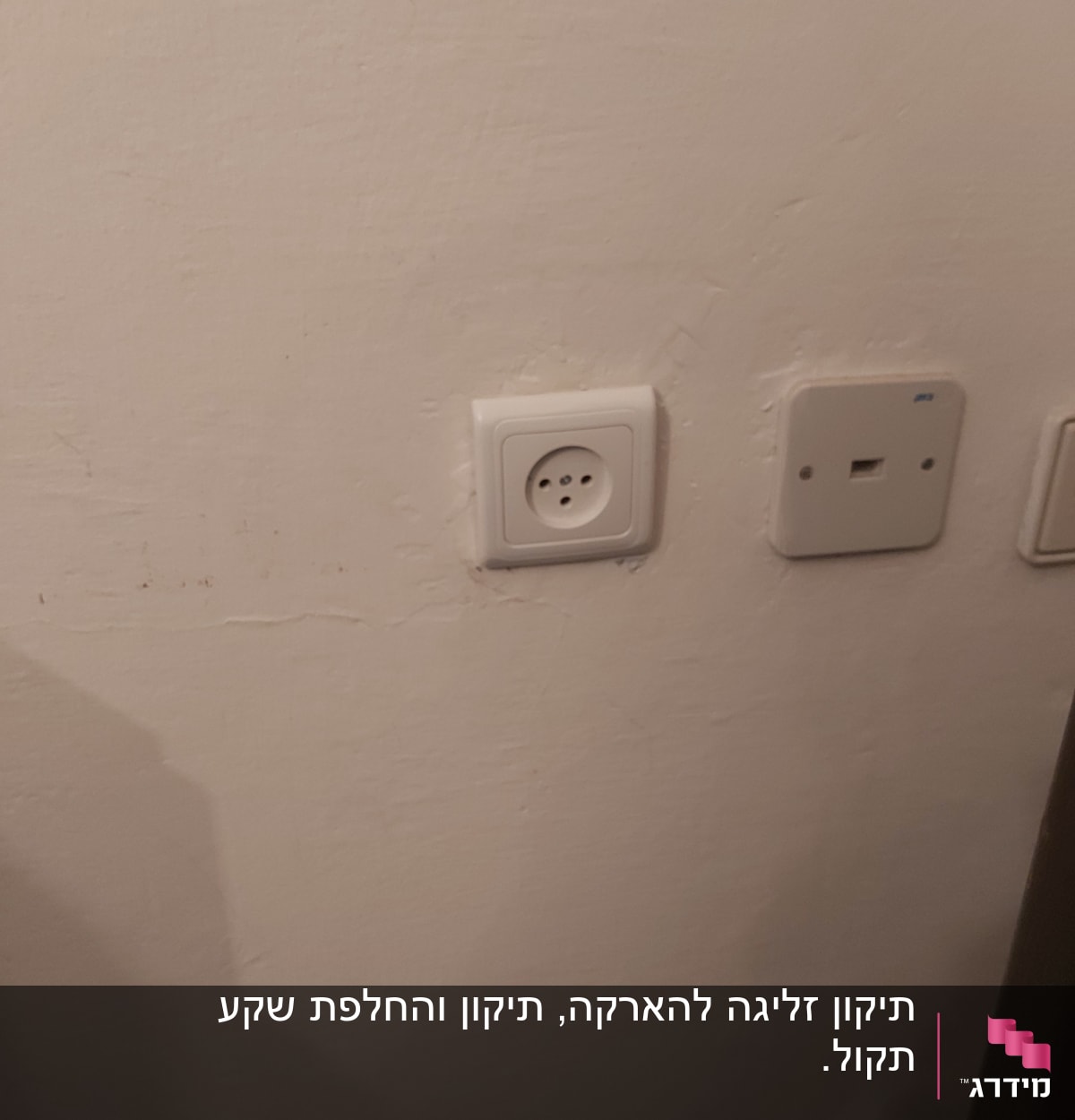 שקע חשמל ולוח תקשורת על קיר לבן